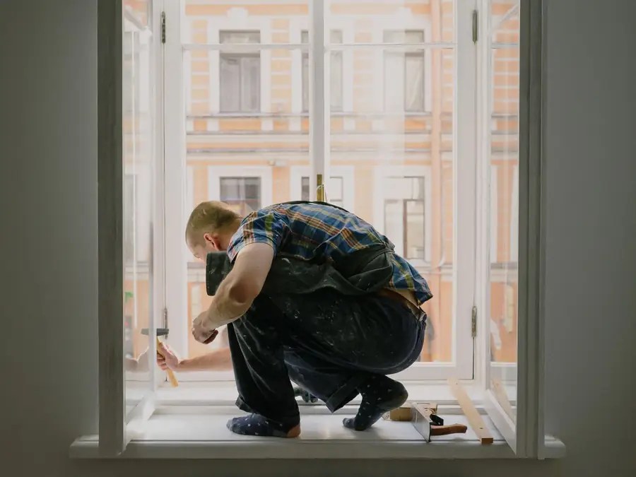 Artisan sur un appui de fenêtre pendant la pose
