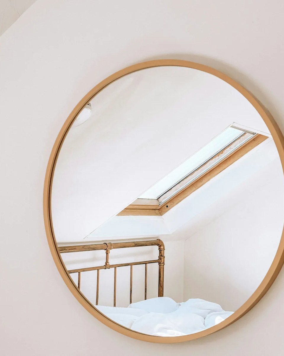 Miroir rond cerclé de laiton dans une chambre claire