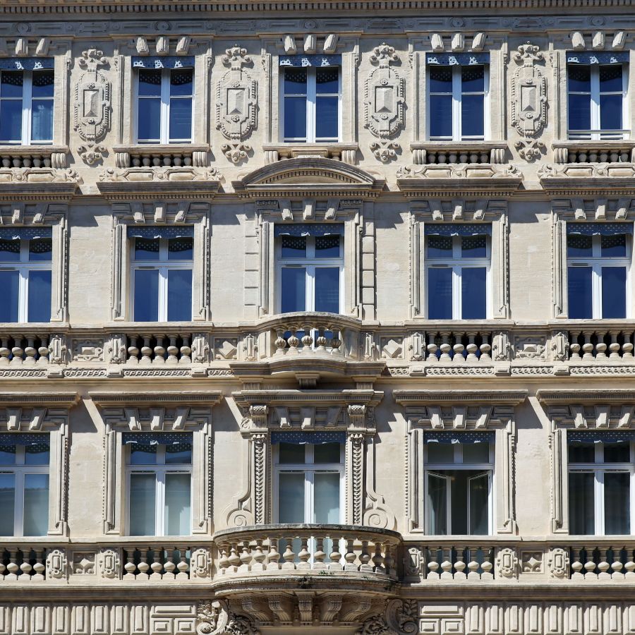 Façade ancienne sculptée aux fenêtres à petits carreaux