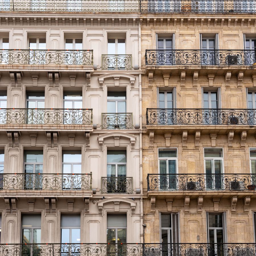Immeuble ancien aux hautes fenêtres et balcons en fer forgé